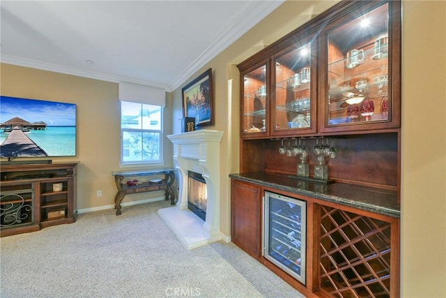 bar with light colored carpet, wine cooler, ornamental molding, and dark stone countertops