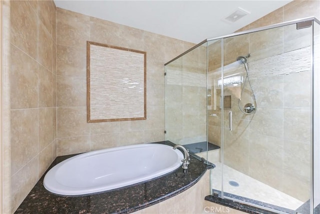 bathroom featuring separate shower and tub, lofted ceiling, and tile walls