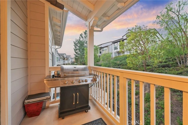 balcony at dusk featuring a grill