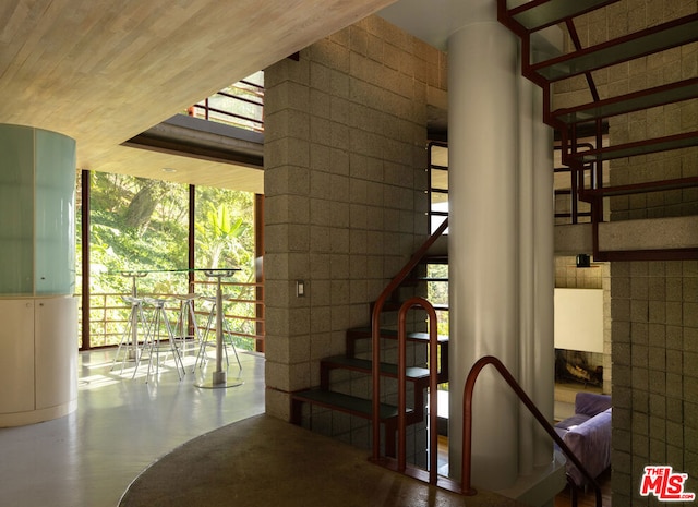 stairs featuring concrete flooring