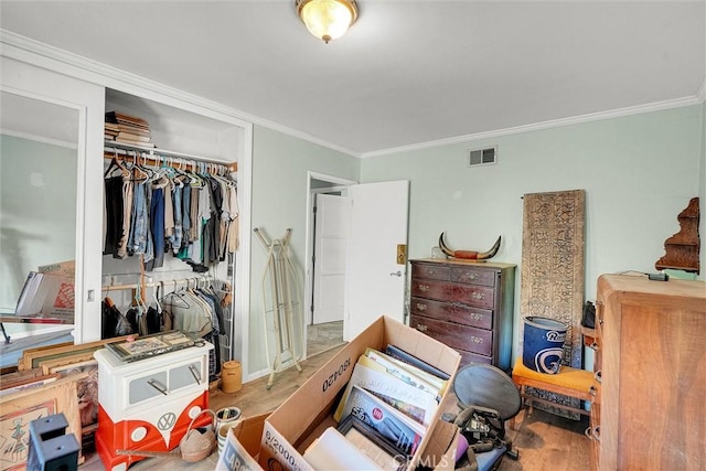 bedroom featuring a closet, crown molding, and wood-type flooring