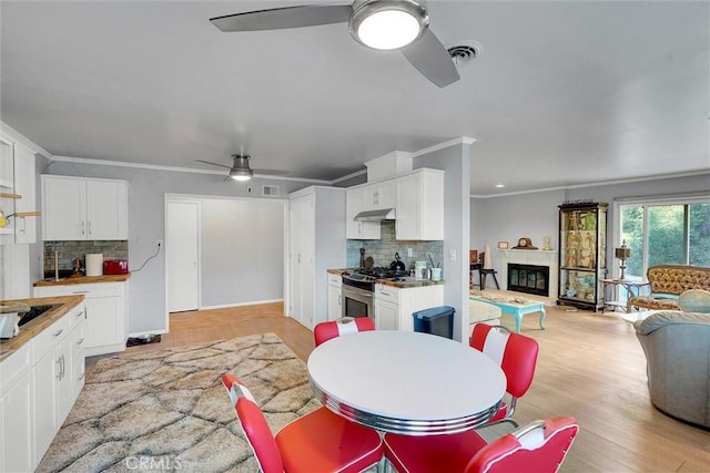 dining room with ceiling fan, ornamental molding, and light hardwood / wood-style flooring