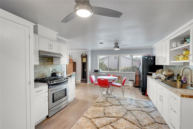 kitchen featuring backsplash, sink, stainless steel range with gas stovetop, white cabinetry, and ornamental molding