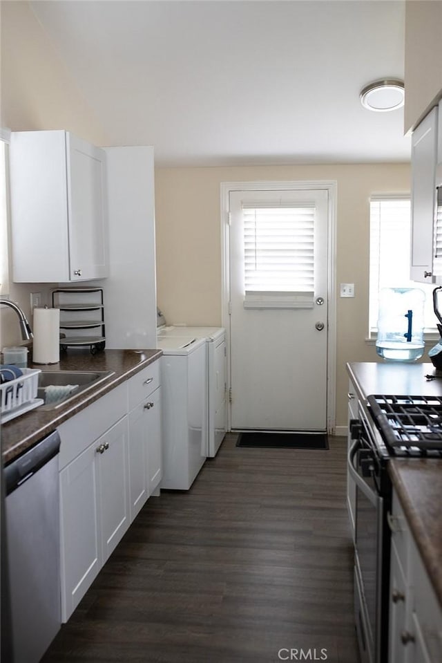 kitchen with sink, dark hardwood / wood-style flooring, washer and clothes dryer, white cabinets, and appliances with stainless steel finishes