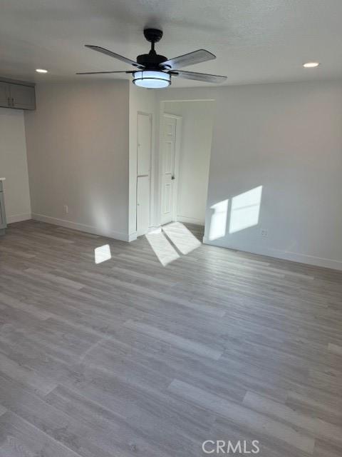 unfurnished room with light wood-type flooring and ceiling fan