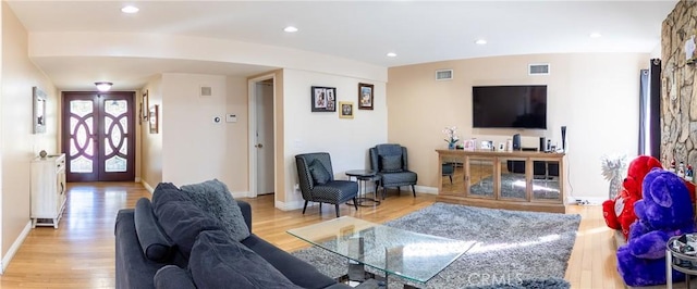 living room with french doors and light hardwood / wood-style flooring