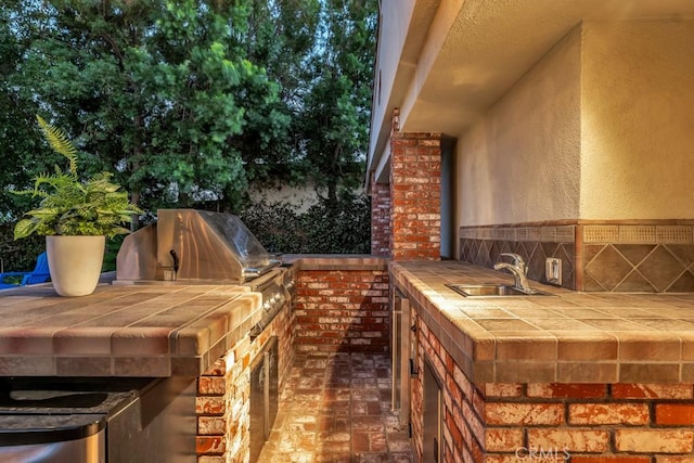 view of patio / terrace featuring an outdoor kitchen, area for grilling, and sink