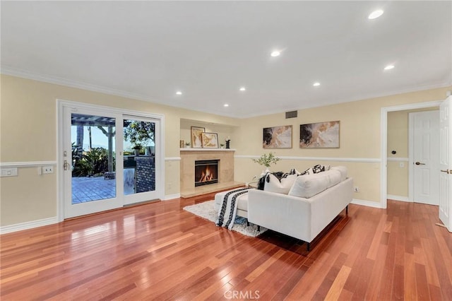 living room featuring crown molding and light hardwood / wood-style flooring