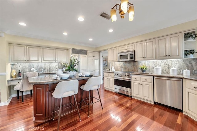 kitchen featuring tasteful backsplash, stainless steel appliances, a kitchen island, and dark hardwood / wood-style floors