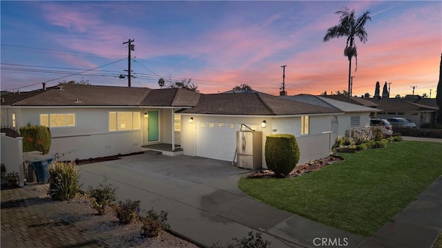 single story home with a garage and a lawn