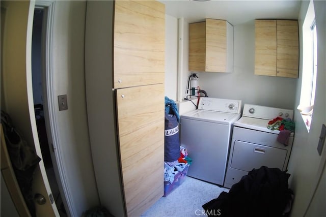 washroom with washer and clothes dryer and cabinets