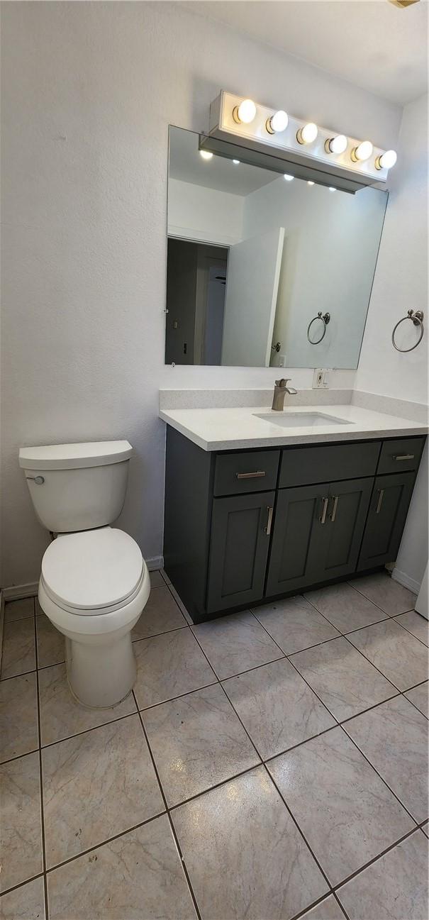 bathroom featuring tile patterned flooring, vanity, and toilet