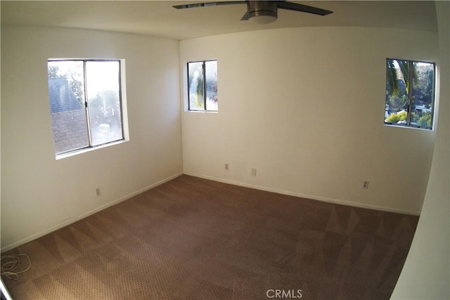 carpeted spare room with plenty of natural light and ceiling fan