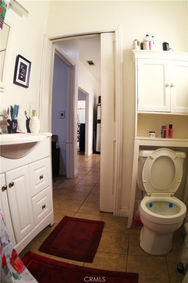 bathroom featuring tile patterned flooring, vanity, and toilet