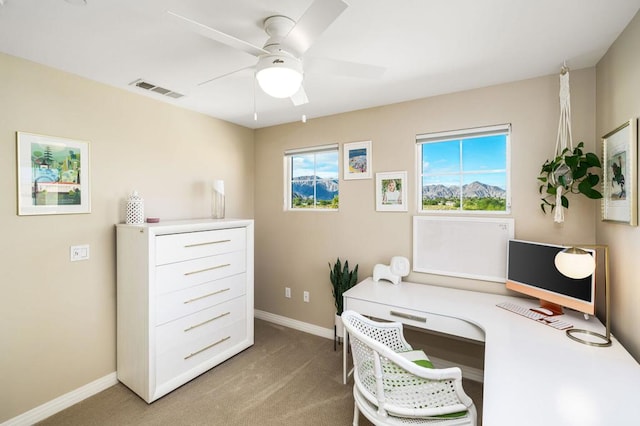 office space featuring light carpet, plenty of natural light, and ceiling fan