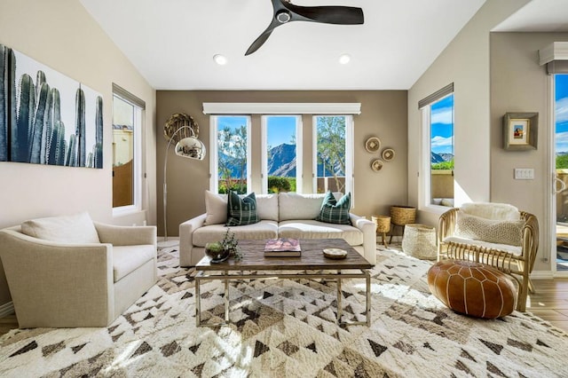 living room featuring ceiling fan, light hardwood / wood-style floors, and vaulted ceiling