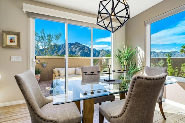 dining area with a mountain view and light hardwood / wood-style flooring