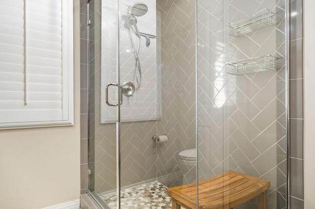 bathroom featuring an enclosed shower and toilet