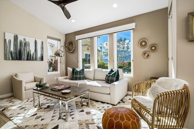 living room featuring ceiling fan, lofted ceiling, and light hardwood / wood-style flooring