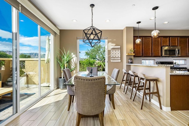 dining area with light hardwood / wood-style floors and a chandelier