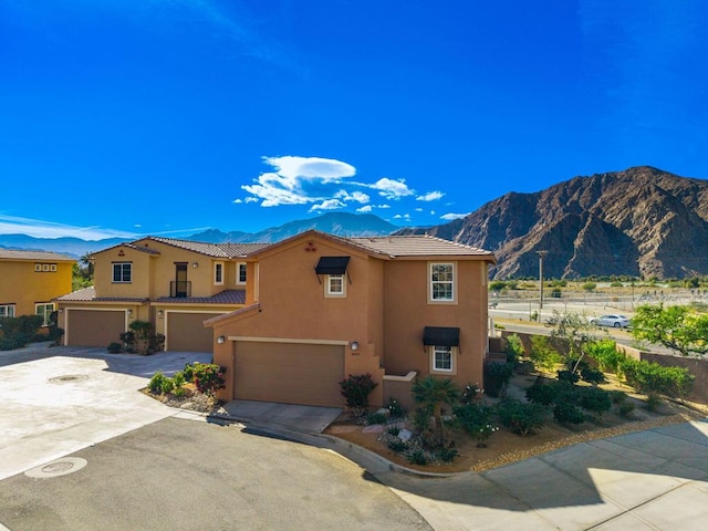 mediterranean / spanish-style home with a mountain view and a garage