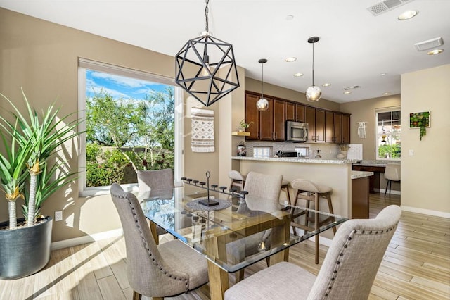 dining room with plenty of natural light and light hardwood / wood-style flooring