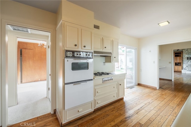 kitchen with white appliances and light wood-type flooring