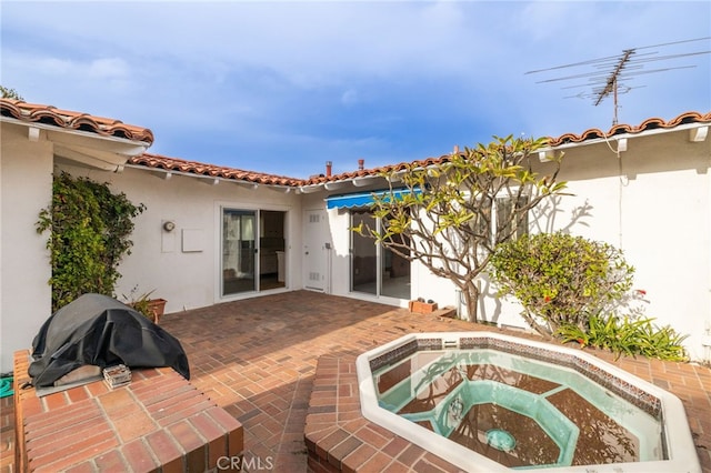 exterior space featuring a patio and a hot tub