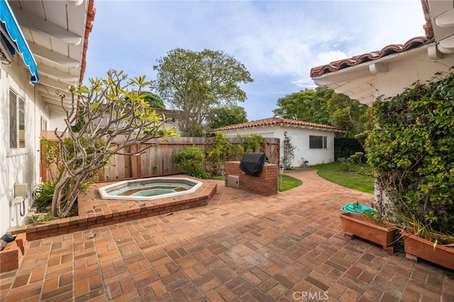 view of patio / terrace with an in ground hot tub and grilling area