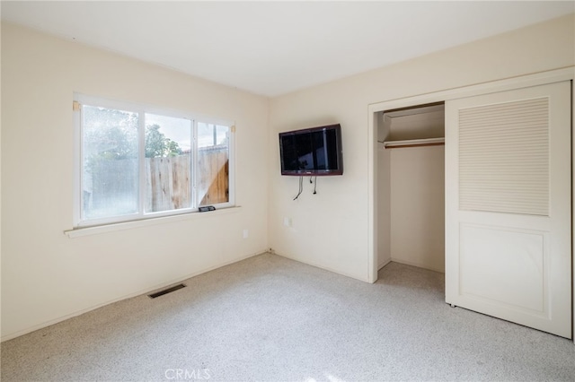 unfurnished bedroom with light carpet and a closet