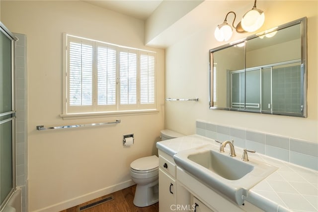 full bathroom with vanity, shower / bath combination with glass door, toilet, and wood-type flooring