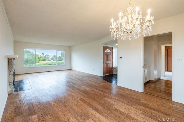 unfurnished room with a notable chandelier and dark hardwood / wood-style flooring