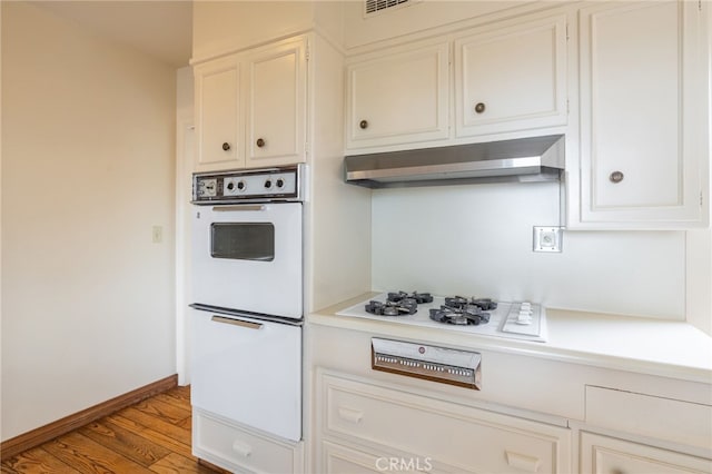 kitchen with hardwood / wood-style flooring, white cabinetry, and white gas stovetop