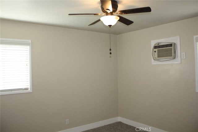 carpeted empty room featuring ceiling fan, baseboards, and a wall mounted AC