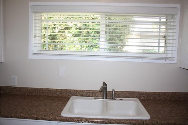 kitchen with dark countertops, a sink, and a wealth of natural light