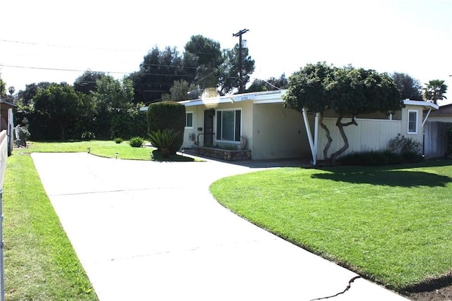 single story home with curved driveway, stucco siding, an attached carport, and a front lawn
