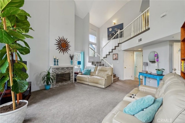 living room with carpet flooring, a stone fireplace, and high vaulted ceiling