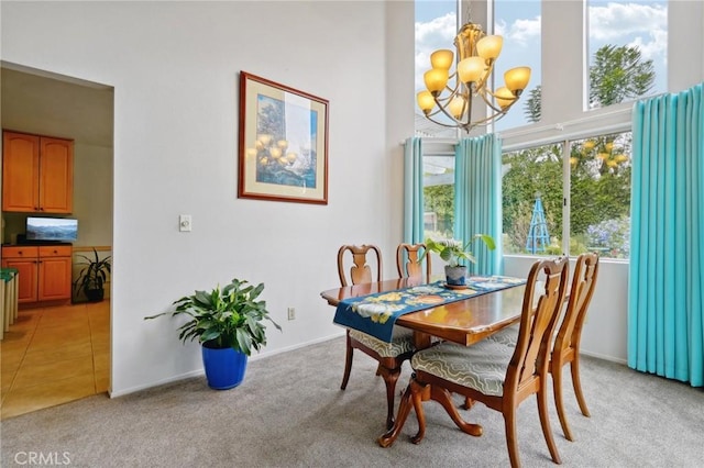 carpeted dining room featuring a notable chandelier