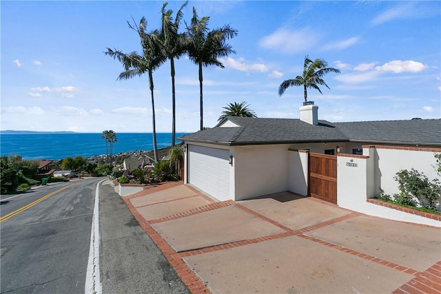 view of front of house featuring a garage and a water view