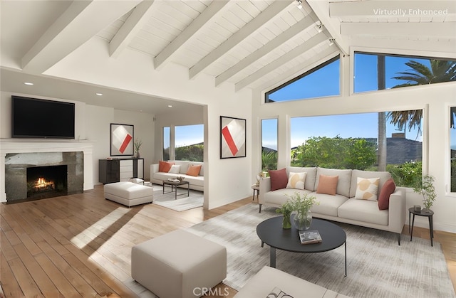 living room featuring beamed ceiling, high vaulted ceiling, a fireplace, and light hardwood / wood-style flooring