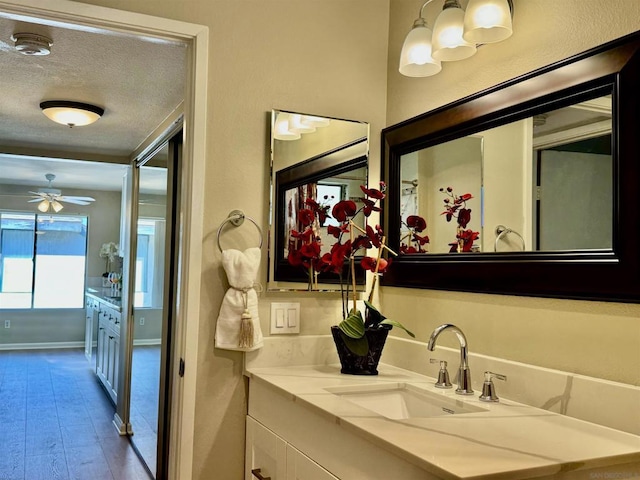 bathroom featuring vanity, hardwood / wood-style floors, a textured ceiling, and ceiling fan