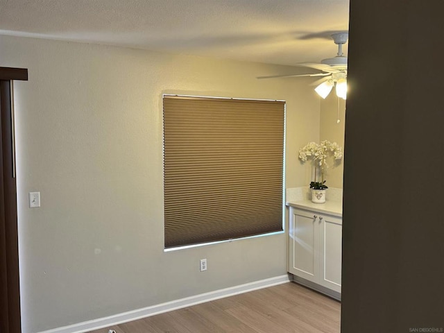 empty room with ceiling fan and light hardwood / wood-style floors