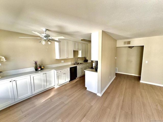 kitchen with white cabinets, sink, light hardwood / wood-style flooring, ceiling fan, and black dishwasher