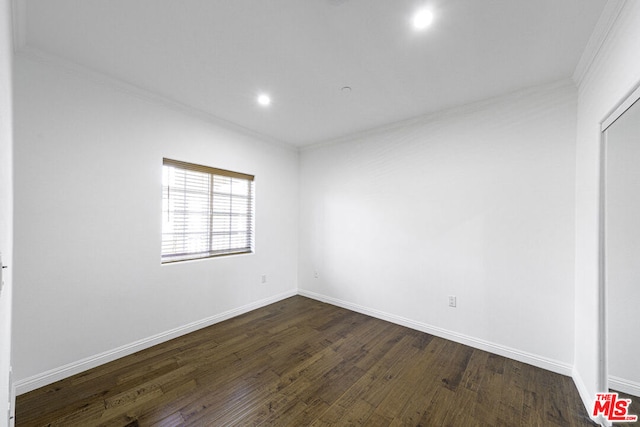 unfurnished room featuring ornamental molding and dark wood-type flooring