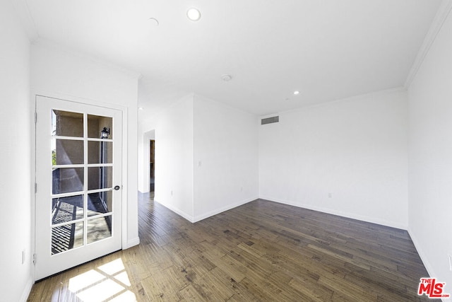 spare room featuring dark hardwood / wood-style floors and ornamental molding