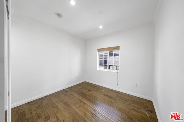 empty room with crown molding and wood-type flooring