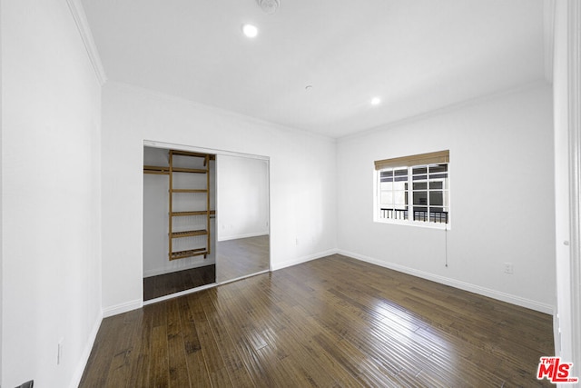 empty room with dark hardwood / wood-style flooring and ornamental molding