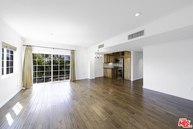 unfurnished living room with dark hardwood / wood-style flooring, a chandelier, and ornamental molding