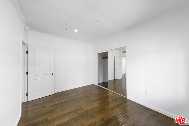 unfurnished bedroom with dark hardwood / wood-style flooring, a closet, and ornamental molding