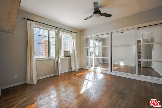 spare room featuring ceiling fan, cooling unit, and wood-type flooring